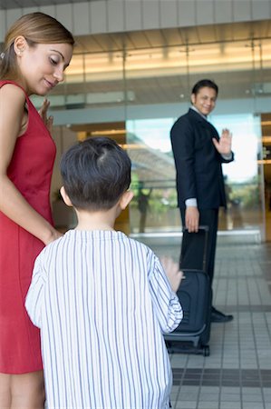 Businessman waving to his wife and son at an airport Stock Photo - Premium Royalty-Free, Code: 630-01492819