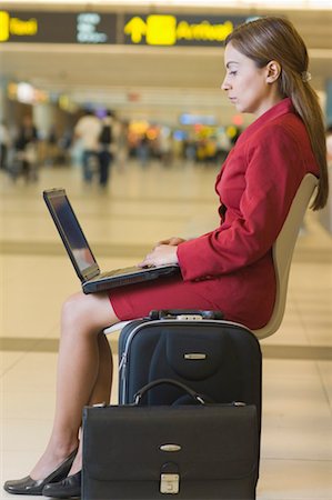 Mid adult woman using a laptop at an airport lounge Stock Photo - Premium Royalty-Free, Code: 630-01492824