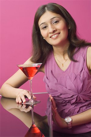 pakistani ethnicity - Portrait of a young woman holding a martini and smiling Stock Photo - Premium Royalty-Free, Code: 630-01492912