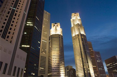 Low angle view of skyscrapers lit up at dusk, Singapore Stock Photo - Premium Royalty-Free, Code: 630-01707810