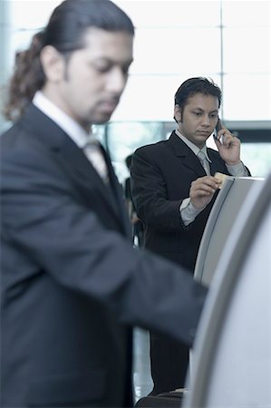 simsearch:630-01873072,k - Two businessmen using express check-in service at an airport Stock Photo - Premium Royalty-Free, Code: 630-01707890