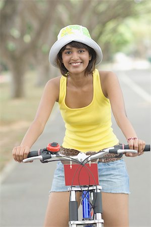 simsearch:630-01491738,k - Portrait of a young woman riding a bicycle and smiling Stock Photo - Premium Royalty-Free, Code: 630-01708055