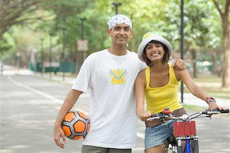 simsearch:630-01296756,k - Portrait of a young man standing with a young woman riding a bicycle Foto de stock - Sin royalties Premium, Código: 630-01708059