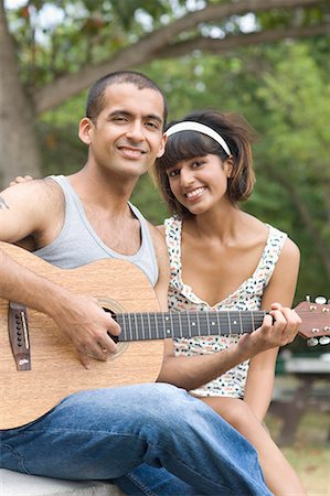 simsearch:630-01491738,k - Portrait of a young man sitting with his girlfriend and playing a guitar Stock Photo - Premium Royalty-Free, Code: 630-01708109