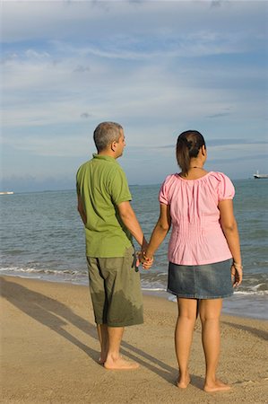 Rear view of a mid adult couple holding hands of each other on the beach Stock Photo - Premium Royalty-Free, Code: 630-01708170