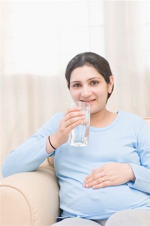 Portrait of a pregnant woman drinking water from a glass Stock Photo - Premium Royalty-Free, Code: 630-01708221