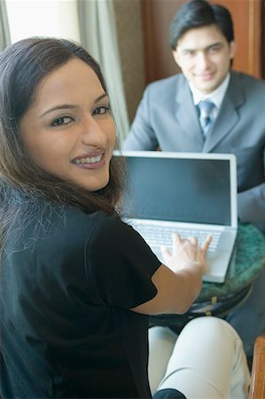 Portrait d'une femme d'affaires à l'aide d'un ordinateur portable en face d'un homme d'affaires dans un hôtel Photographie de stock - Premium Libres de Droits, Code: 630-01708449