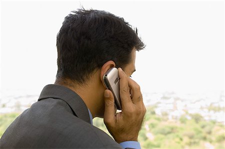 phone with indian man backside - Close-up of a businessman talking on a mobile phone Stock Photo - Premium Royalty-Free, Code: 630-01708494