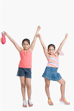 Portrait of two girls posing with arms raised Stock Photo - Premium Royalty-Free, Code: 630-01709122