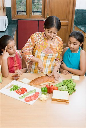 pic of indian kid eating breakfast - Mid adult woman making sandwich with her daughters Stock Photo - Premium Royalty-Free, Code: 630-01709130