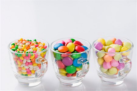 Row of three cups filled with jellybeans and candies Stock Photo - Premium Royalty-Free, Code: 630-01709482