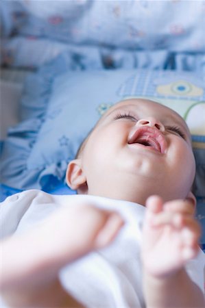 Close-up of a baby lying down and laughing Stock Photo - Premium Royalty-Free, Code: 630-01709573