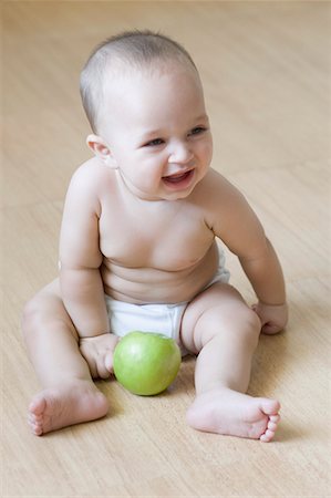 Baby boy sitting on the hardwood floor and laughing Stock Photo - Premium Royalty-Free, Code: 630-01709585