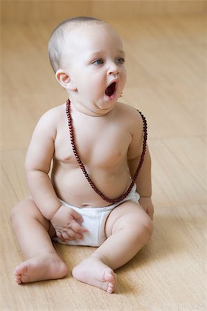 Baby boy sitting on the hardwood floor and yawning Stock Photo - Premium Royalty-Free, Code: 630-01709587