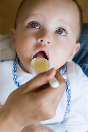 Close-up of a person's hand feeding food to a baby boy Stock Photo - Premium Royalty-Free, Code: 630-01709582