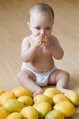 High angle view of a baby boy eating mango Stock Photo - Premium Royalty-Free, Code: 630-01709600