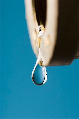 Close-up of a water drop dripping from a faucet Stock Photo - Premium Royalty-Free, Code: 630-01709792