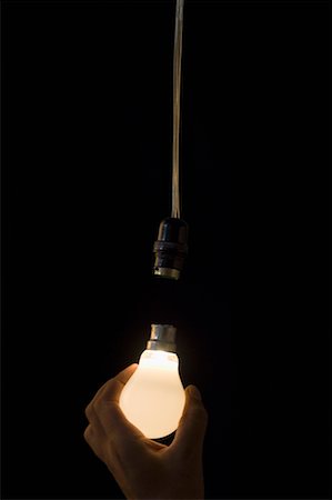 Close-up of a person's hand holding an illuminated light bulb Stock Photo - Premium Royalty-Free, Code: 630-01709845