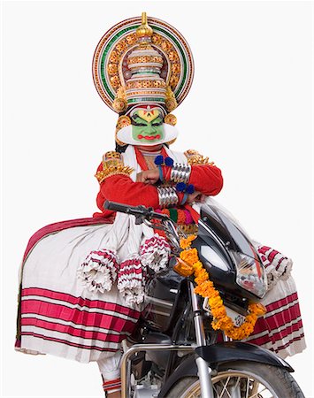 Portrait of a Kathakali dance performer sitting on a motorcycle Foto de stock - Sin royalties Premium, Código: 630-01709983