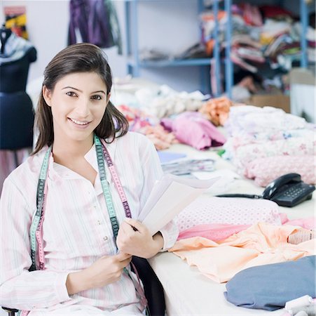 fashion industry - Portrait of a female fashion designer sitting in a textile industry and smiling Stock Photo - Premium Royalty-Free, Code: 630-01874295