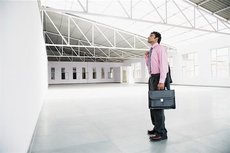 Side profile of a businessman holding a briefcase Stock Photo - Premium Royalty-Free, Code: 630-01874426