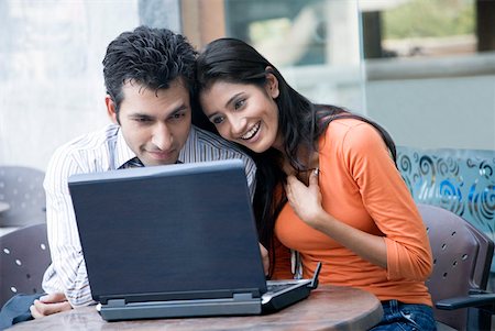 Jeune couple à l'aide d'un ordinateur portable et souriant Photographie de stock - Premium Libres de Droits, Code: 630-01874507