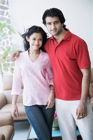 simsearch:649-06716867,k - Portrait of a young couple standing in a living room and smiling Stock Photo - Premium Royalty-Free, Code: 630-01874573
