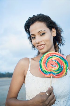simsearch:630-01709492,k - Portrait of a young woman holding a candy and smiling Stock Photo - Premium Royalty-Free, Code: 630-01875184