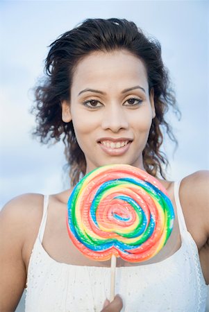 simsearch:630-01709492,k - Portrait of a young woman holding a candy and smiling Stock Photo - Premium Royalty-Free, Code: 630-01875185
