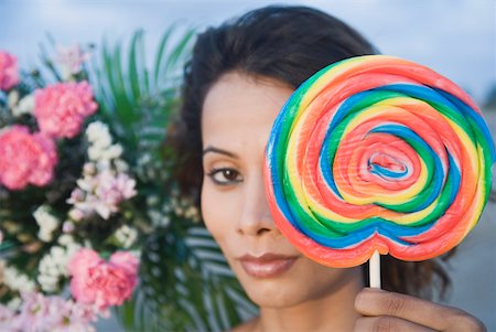 simsearch:630-01709492,k - Portrait of a young woman holding a candy Stock Photo - Premium Royalty-Free, Code: 630-01875188