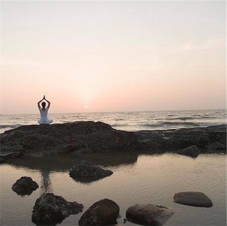 Rear view of a woman meditating on the beach Stock Photo - Premium Royalty-Free, Code: 630-01875519