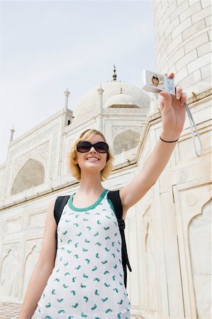 Low angle view of a young woman taking a picture of herself, Taj Mahal, Agra, Uttar Pradesh, India Stock Photo - Premium Royalty-Free, Code: 630-01876288