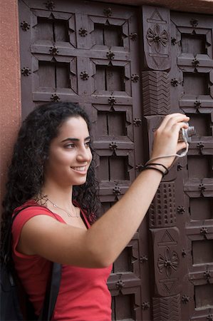 Close-up of a young woman taking a picture with a digital camera, Taj Mahal, Agra, Uttar Pradesh, India Stock Photo - Premium Royalty-Free, Code: 630-01876323