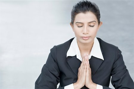 Close-up of a businesswoman meditating in prayer position Stock Photo - Premium Royalty-Free, Code: 630-01876382