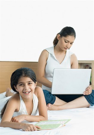 Portrait of a girl lying on the bed and her mother using a laptop Foto de stock - Sin royalties Premium, Código: 630-01876426
