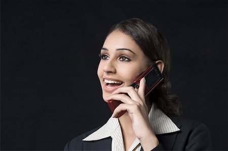 simsearch:630-01876527,k - Gros plan d'une femme d'affaires parlant sur un téléphone mobile et souriant Photographie de stock - Premium Libres de Droits, Code: 630-01876494