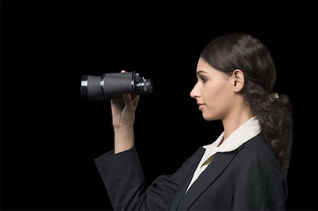 Side profile of a businesswoman looking through a pair of binoculars Stock Photo - Premium Royalty-Free, Code: 630-01876500