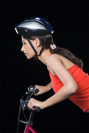 simsearch:630-01876527,k - Profil de côté d'un cycliste féminine enfourcher une bicyclette Photographie de stock - Premium Libres de Droits, Code: 630-01876581