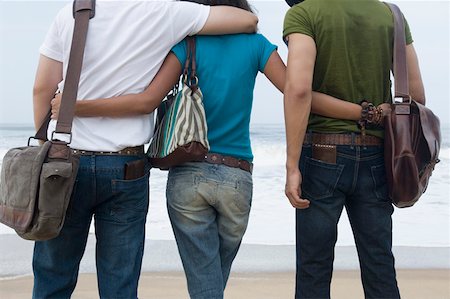 Rear view of a woman with her arms around two men Stock Photo - Premium Royalty-Free, Code: 630-01876983