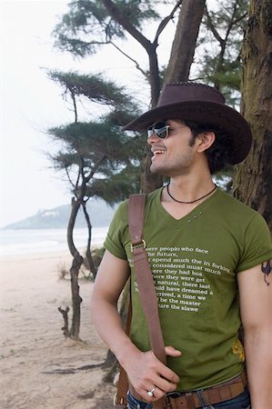 Close-up of a young man standing on the beach and smiling Stock Photo - Premium Royalty-Free, Code: 630-01876994