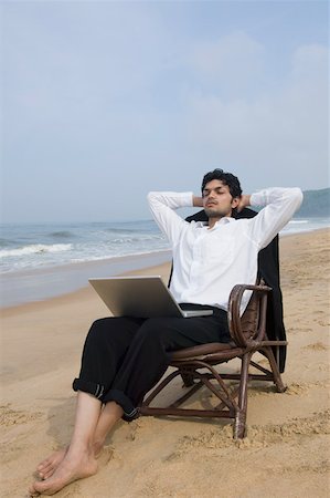 Businessman sitting in an armchair with a laptop on the beach Stock Photo - Premium Royalty-Free, Code: 630-01877047