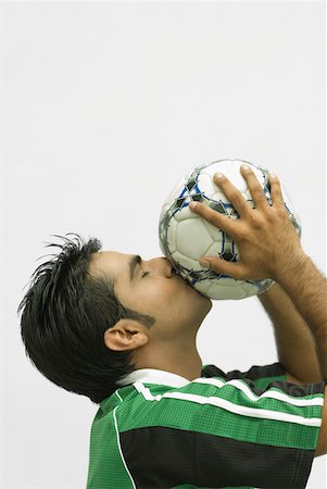 Close-up of a young man kissing a soccer ball Stock Photo - Premium Royalty-Free, Code: 630-01877119