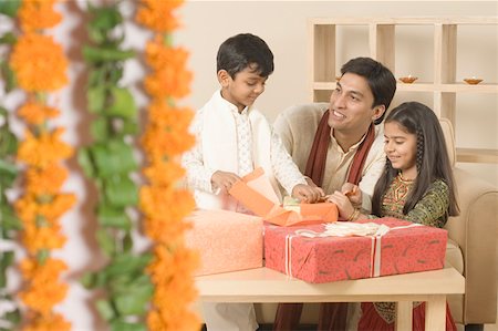 simsearch:630-01873032,k - Young man sitting with his children and opening diwali gifts Stock Photo - Premium Royalty-Free, Code: 630-01877216