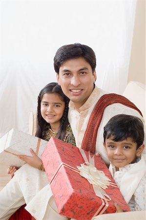 simsearch:630-01873032,k - Portrait of a young man sitting with his son and daughter and holding diwali gifts Stock Photo - Premium Royalty-Free, Code: 630-01877213