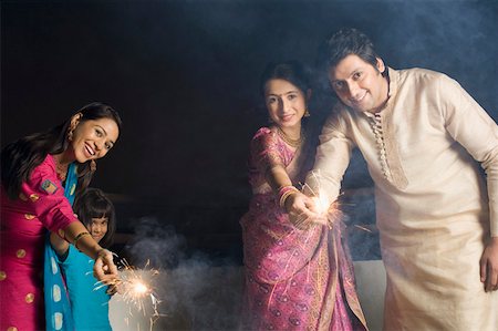 Portrait of a mid adult man with two young women and a girl celebrating a diwali festival Foto de stock - Sin royalties Premium, Código: 630-01877389