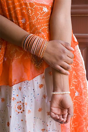 Mid section view of a teenage girl wearing bangles Stock Photo - Premium Royalty-Free, Code: 630-01877695