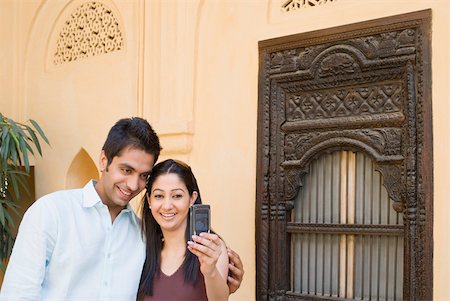 simsearch:630-01876693,k - Young couple taking a photograph of themselves with a mobile phone Stock Photo - Premium Royalty-Free, Code: 630-01872400