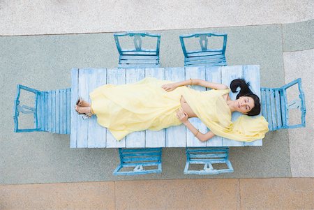 High angle view of a young woman lying on a table Stock Photo - Premium Royalty-Free, Code: 630-01872512