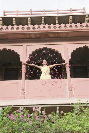 simsearch:630-01872552,k - Woman throwing flowers from balcony, Neemrana Fort Palace, Neemrana, Alwar, India Stock Photo - Premium Royalty-Free, Code: 630-01872541