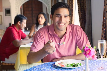 Portrait d'un jeune homme assis dans un restaurant et souriant Photographie de stock - Premium Libres de Droits, Code: 630-01872788